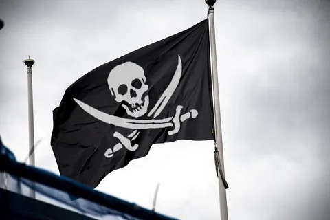 Musta Jolly Roger -merirosvolippu, jossa on valkoinen pääkallo ja ristikkäiset luut