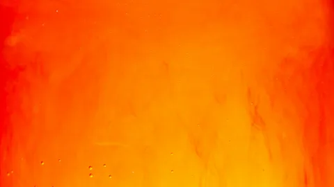 Oransseja liekkejä ja vesipisaroita lähikuvassa